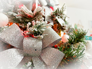 Silver bow and snowy branches of a Christmas tree