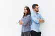 © Mangostar - Annoyed upset couple standing back-to-back with arms crossed. Young woman in casual and man in glasses posing isolated over white background. Conflict in couple concept