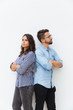 © Mangostar - Sad unhappy couple standing back-to-back with arms crossed. Young woman in casual and man in glasses in glasses posing isolated over white background. Breakup concept