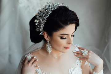 Beautiful bride portrait wedding makeup and hairstyle with diamond crown, fashion bride model jewelry and beauty girl face, gorgeous beauty bride. Beautiful girl with closed makeup eyes 