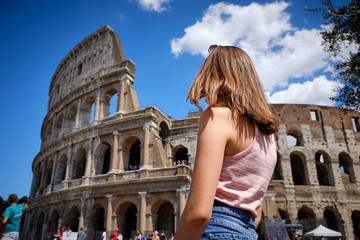 Travel in Rome. Back view of beautiful girl visiting Colosseum landmark. Summer holidays in Italy.