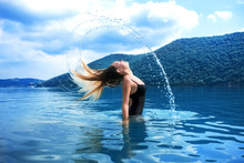 Beautiful Girl Splashing In The Water. Retreat. Vacation. Colorful Blue Landscape. Rest, Relax In Nature. Enjoy Life. Lifestyle. A Young Woman Swimming In The Sea. Color Of The Year 2020. Tropical.