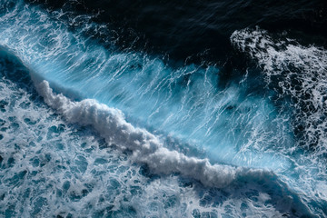 aerial view to waves in ocean splashing waves. blue turbid wavy sea water. bali, indonesia.