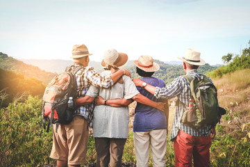 a group of asian seniors hiking and standing on high mountains enjoying nature. senior community con