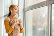 © Pixel-Shot - Beautiful mature woman drinking coffee near window in office