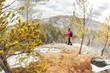 © Baikal360 - hiker man with a backpack stands on top of a mountain above the forest and looks at the valley
