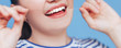 © Anastassiya  - Happy smiling woman with white perfect teeth flossing, dental floss on blue background, clode up photo.
