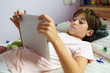 © javiindy - Cute girl using a tablet computer in her bedroom
