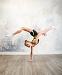 Flexible cute little girl child gymnast doing acrobatic exercise