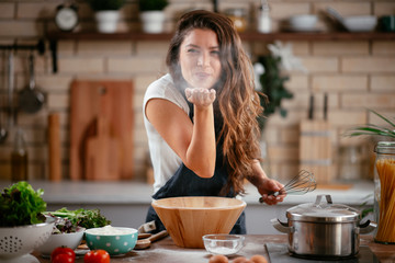 young woman in kitchen. beautiful woman playing with flour.