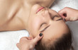 © Dimid - Masseur makes a relaxing massage on the face, neck, shoulders and collarbones of a young beautiful woman in a spa. Cosmetology and massage concept.