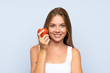 © luismolinero - Young blonde girl with an apple over isolated background