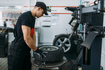 Wall Mural - Mechanic fixing wheel on tire fitting machine