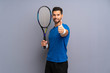© luismolinero - Handsome young tennis player man with thumbs up because something good has happened