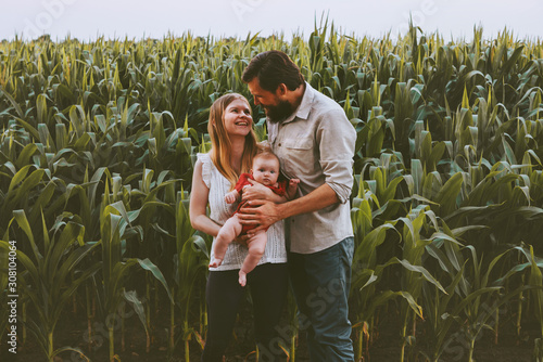 Happy farmers family parents with infant baby outdoor mother and father with child together healthy lifestyle agriculture vegan people