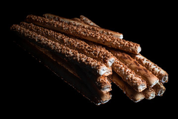 Wall Mural - Salted snacks with sesame seeds with reflection on shiny black background