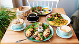 Colorful and diffrent meals on healthy breakfast on a table in restaurant. Vegetarian food with coffee for lunch. Omelette, bruchetta and toast on a plate. Close up. Panoramic banner.