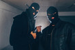 Thiefs with masks holding gun in dark room