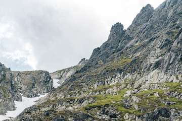 Detail of a mountain rock face, background or wallpaper picture of big wall rock climb, clouds and mist, stone and rock surface. Huge rock wall of granite in High Tatras, Slovakia.