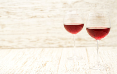 two glasses of red wine on a white wooden background, with copy space.