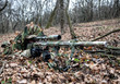 © Getmilitaryphotos - Army sniper hiding on ground in forest leaves