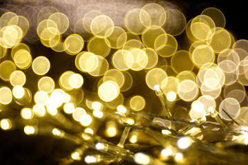 Yellow LED light (and its wire) with gold bubble blur background