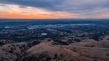 Aerial View Of Open Rolling Hills In Suburban Southern California.  Radio Tower Atop Hill During Sunset Surrounded By Mountains And Ocean