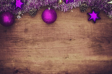 Purple Christmas Decorations On Wooden Background. Flat Lay With Copy Space.