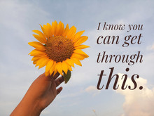 Inspirational Motivational Quote - I Know You Can Get Through This. With Background Of Bright Blue Sky & Young Woman Hand Holds Sunflower Blossom.
