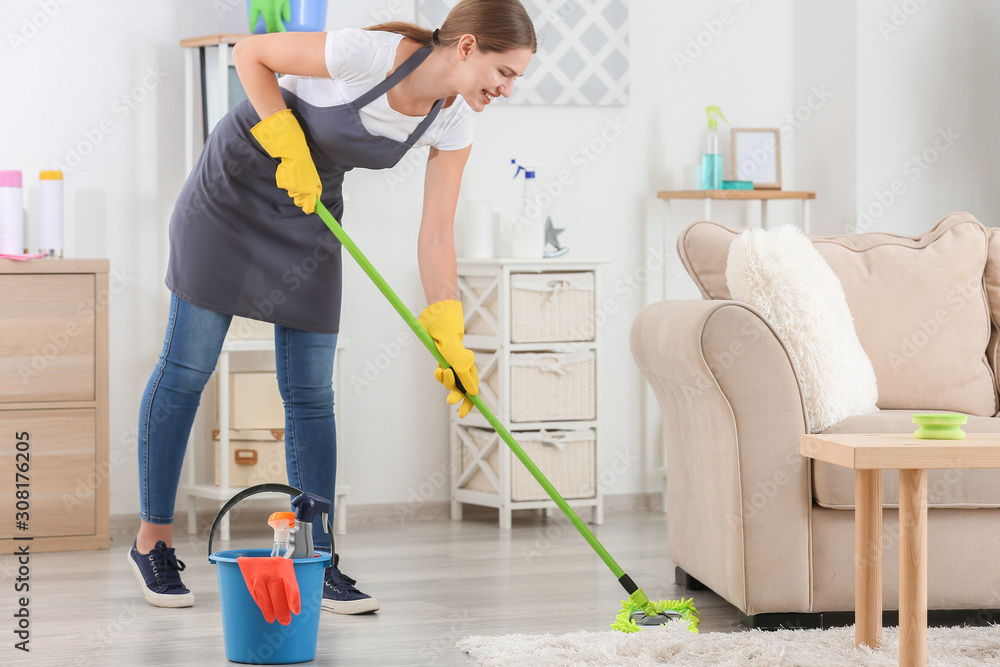 Female janitor mopping floor in room