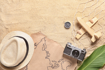 Sticker - Map with photo camera, wooden airplane, compass and hat on sand