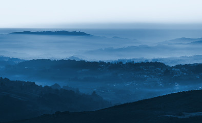 layers of foggy mountains blue toned