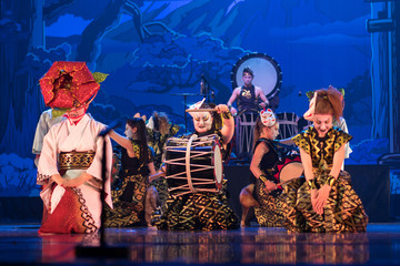 Wall Mural - Traditional Japanese performance. Group of actresses in traditional kimono and hats dancing with taiko drummers on the stage.