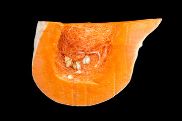 Sliced orange pumpkin, pulp close-up. Isolated on a black background.