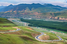 Landscape Of Village In Mountain Valley With Rural Road Winding Up