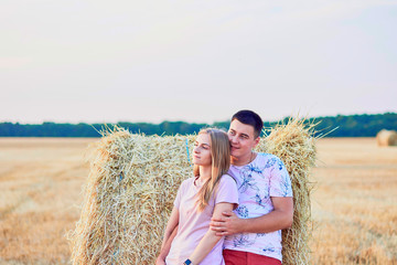 Happy couple in haystack field.