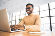 © Prostock-studio - Smiling black guy at flexible office typing on keyboard
