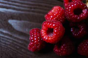 Wall Mural - A handful of raspberries close up on a brown background. Copy space