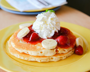 Buttermilk pancake filled with sliced banana and strawberries