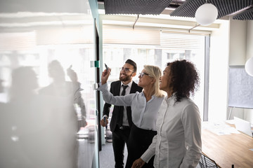 Canvas Print - Motivated diverse employees brainstorm develop strategies on whiteboard