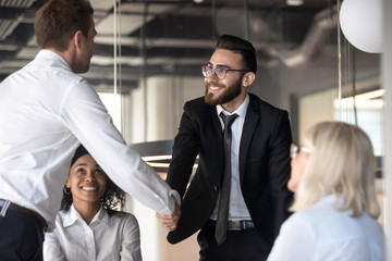 Canvas Print - Multiracial businessmen handshake closing deal at meeting