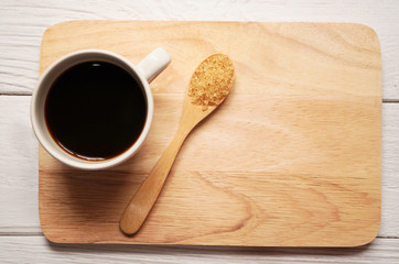 top view of cup of hot americano or espresso black coffee with a spoon of sugar on wooden plate on wooden background ,sweet, calories and diabetes concept