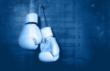 White Leather Boxing Gloves Hanging On Blue Wall