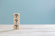 © Mizkit - Wooden cube block with sign question mark symbol on wood table with with copy space