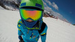 Little boy skiing. Shot of a skier's face..A 6 year old child enjoys a winter holiday in the Alpine resort. .