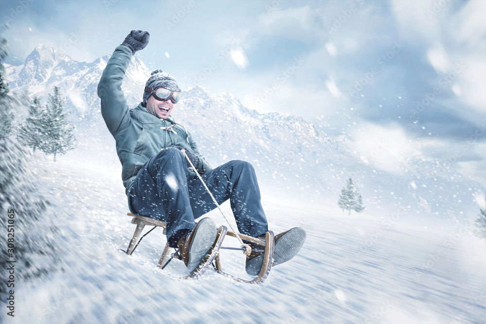 Happy man sledding down a slope in winter - obrazy, fototapety, plakaty 
