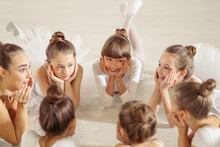 Charming Pretty Little Girls Ballerinas Lying On Floor In Circle, Have A Rest After Performing Ballet Dance In Studio