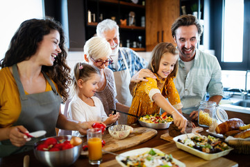 Grandparents, parents and children spending happy time in the kitchen