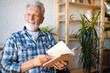 Senior man at home reading book and enjoying retirement, penison