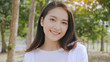© Rapeepat - Asian woman close up face Beautiful, smiling happily, standing in a park with trees. The background is bright green bokeh. Relaxation helps to relax the body. And has a younger face.